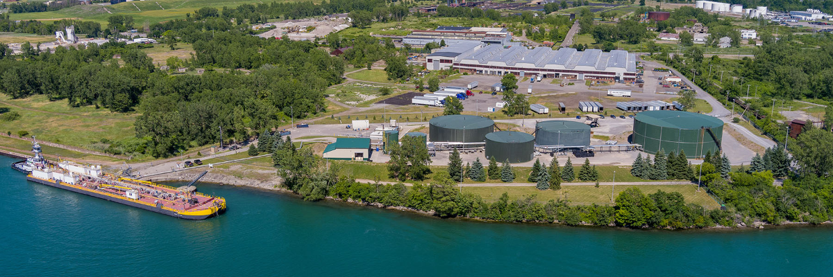 Installations industrielles en bord de mer avec des réservoirs de stockage et un navire amarré